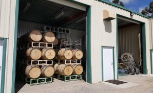 Wine barrels on racks in the barrel room at Wolff Vineyards